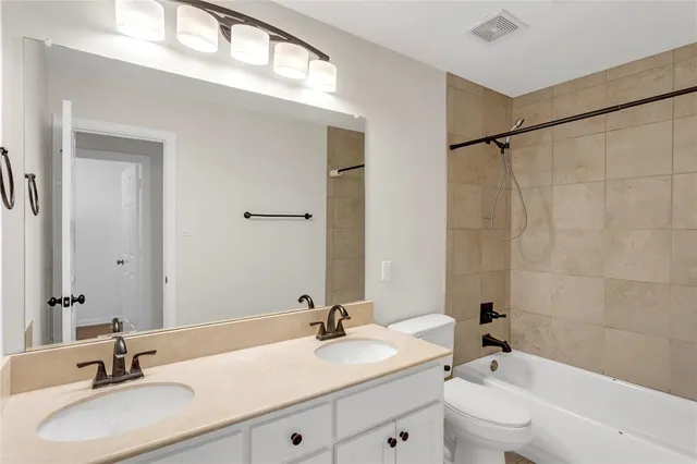 a bathroom with a sink double vanity granite tub shower and a mirror