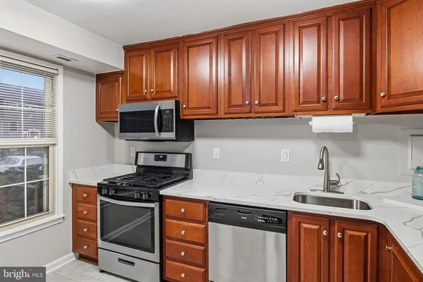 a kitchen with granite countertop a stove top oven cabinetry a sink and dishwasher