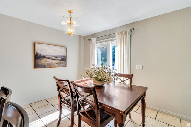 1727 South Sandhill Road Orem, UT 84058 - Photo 10 of 27 Dining area featuring light-toned tile flooring, a window with natural light, and a decorative ceiling light fixture