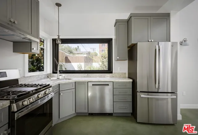 a kitchen with stainless steel appliances granite countertop a stove a sink and a microwave