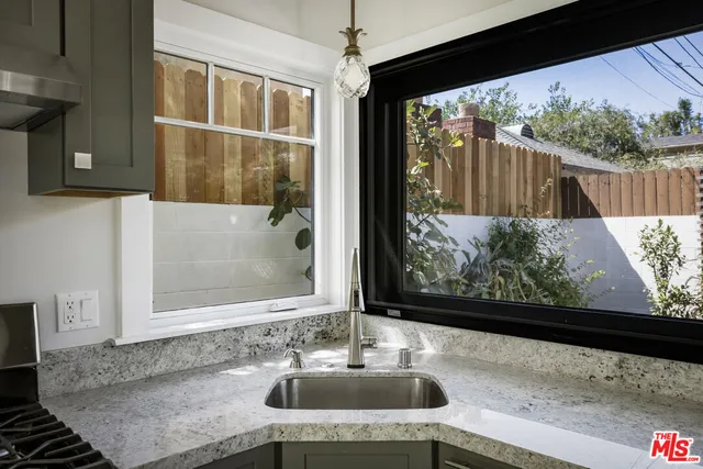 a kitchen with stainless steel appliances kitchen island granite countertop a stove and a sink