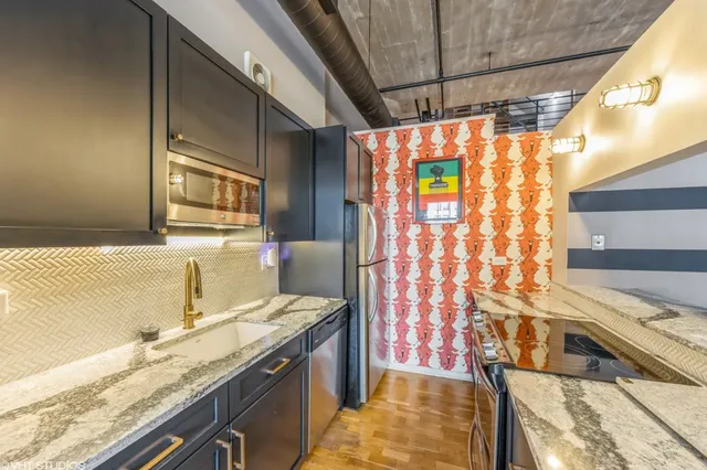 a bathroom with a granite countertop sink and a shower
