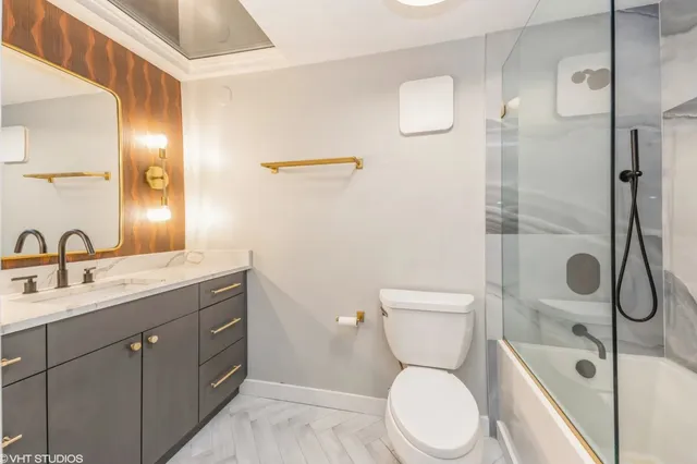 a bathroom with a toilet sink shower and mirror