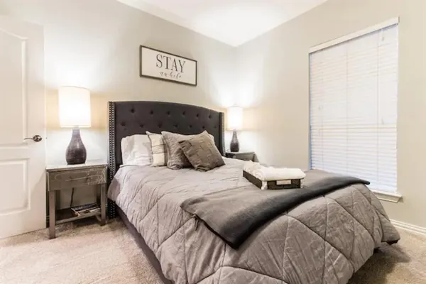 a bedroom with two beds and a lamp on table