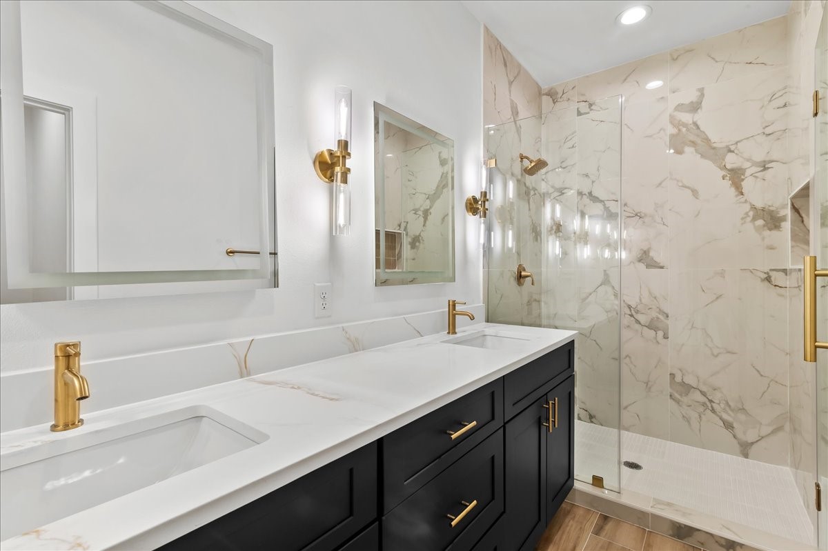 8323 Observatory Street, Unit A/B Houston, TX 77088 - Photo 12 of 38 Unit A - Luxurious primary suite bathroom featuring a spacious walk-in shower with elegant gold fixtures, dual vanities, and LED mirrors, creating a sophisticated spa-like retreat.