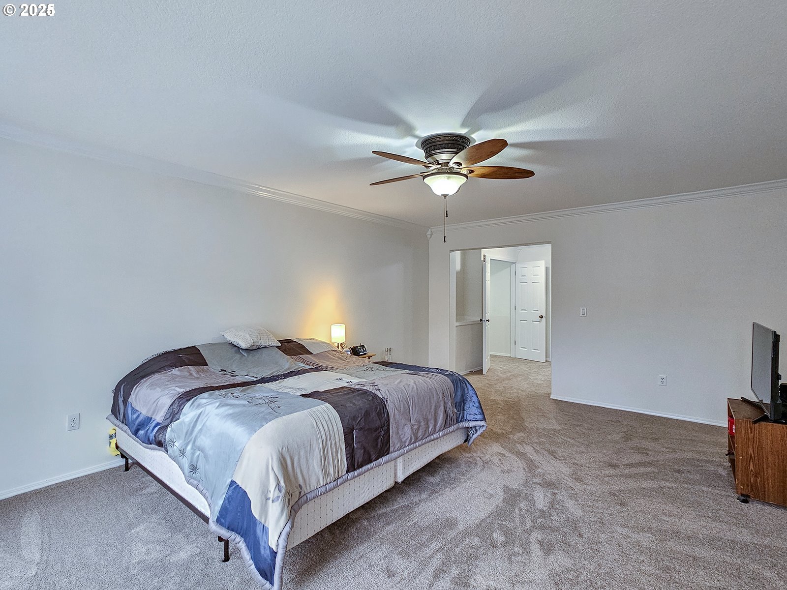 8754 Southwest Wakkila Terrace Beaverton, OR 97007 - Photo 3 of 19 a spacious bedroom with a bed and a chandelier