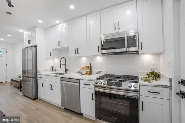 a kitchen with stainless steel appliances a stove a microwave and cabinets