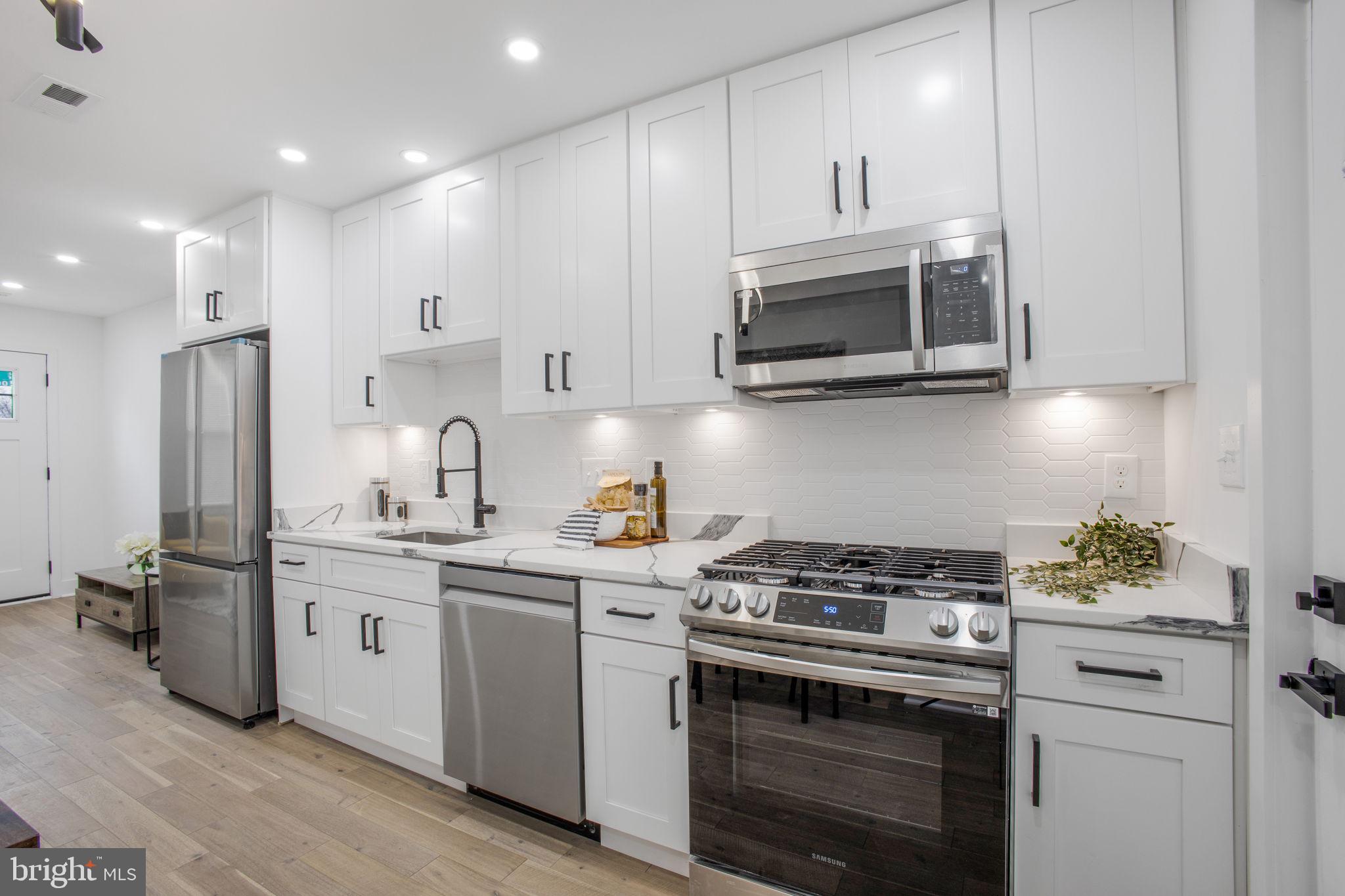 702 19th Street Northeast Washington, DC 20002 - Photo 12 of 38 a kitchen with stainless steel appliances a stove a microwave and cabinets