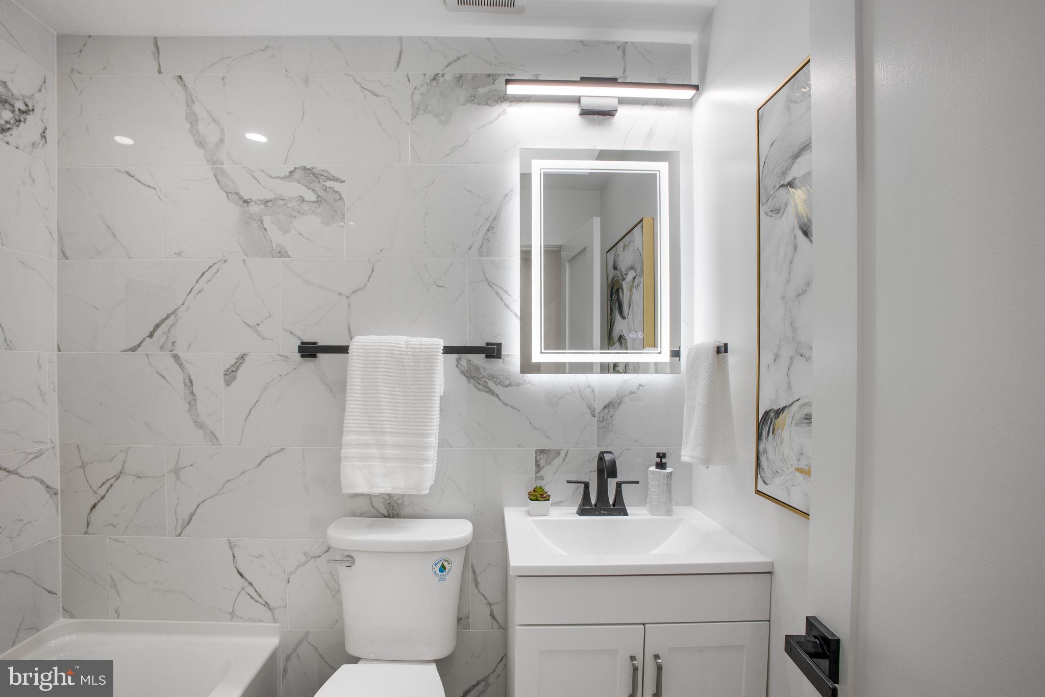 702 19th Street Northeast Washington, DC 20002 - Photo 20 of 38 a bathroom with a toilet sink and mirror
