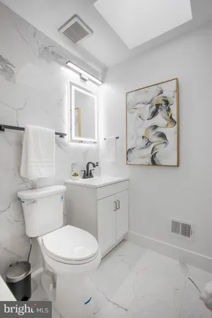 a bathroom with a toilet sink and mirror