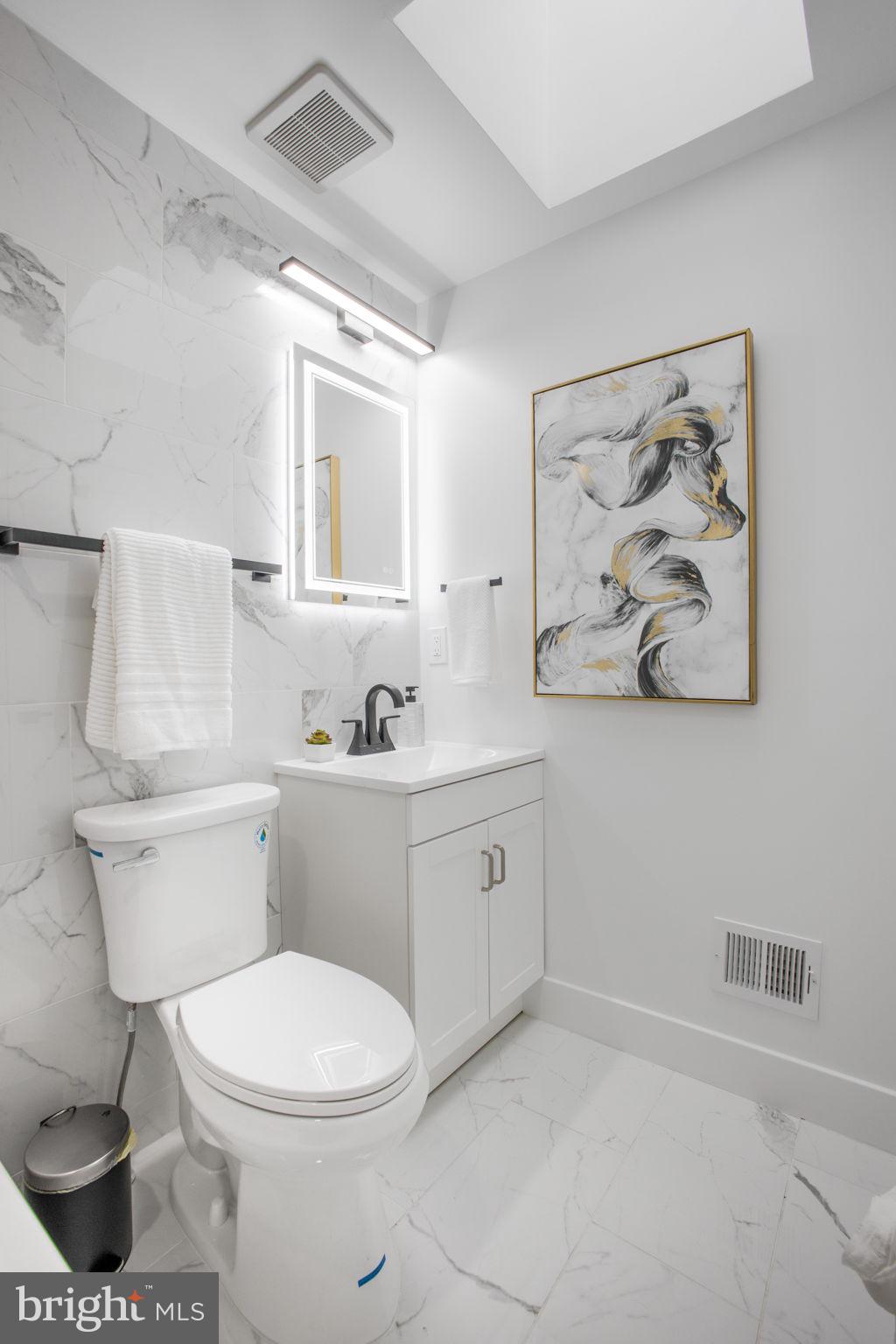 702 19th Street Northeast Washington, DC 20002 - Photo 21 of 38 a bathroom with a toilet sink and mirror