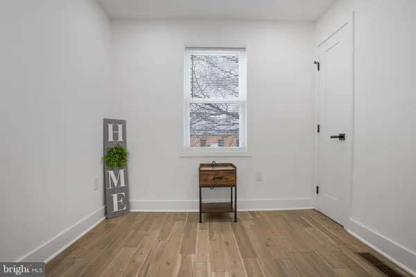 an empty room with a window and wooden floor