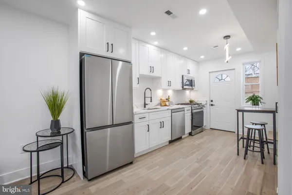 a kitchen with white cabinets and stainless steel appliances