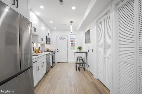 a kitchen with white cabinets and stainless steel appliances