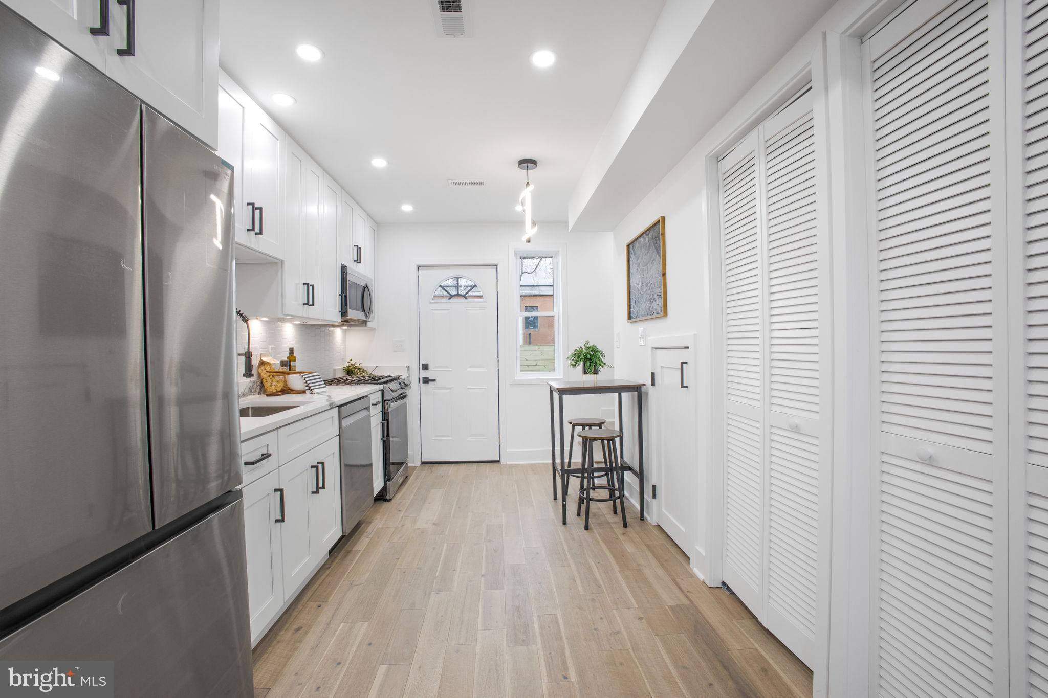 702 19th Street Northeast Washington, DC 20002 - Photo 8 of 38 a kitchen with white cabinets and stainless steel appliances