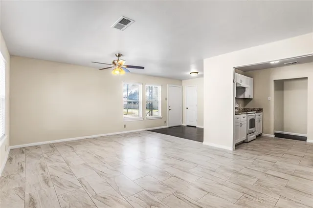 a view of empty room with wooden floor and window