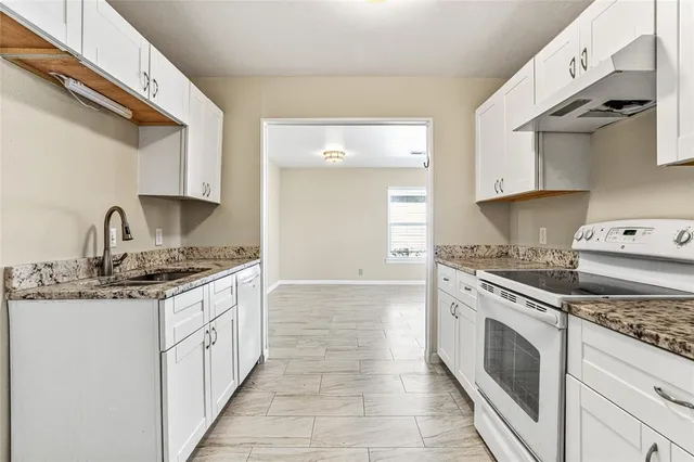 a kitchen with stainless steel appliances granite countertop a stove and a sink