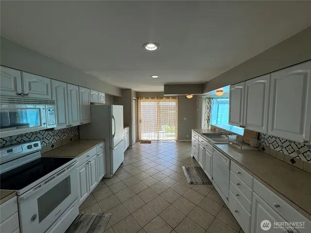 a kitchen with stainless steel appliances granite countertop a sink stove and cabinets