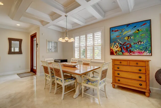 a view of a dining room with furniture a chandelier and a rug