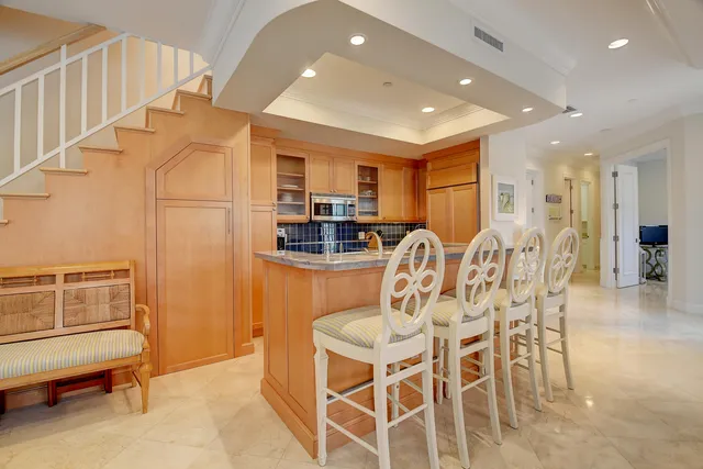 a kitchen with stainless steel appliances kitchen island granite countertop a refrigerator and cabinets