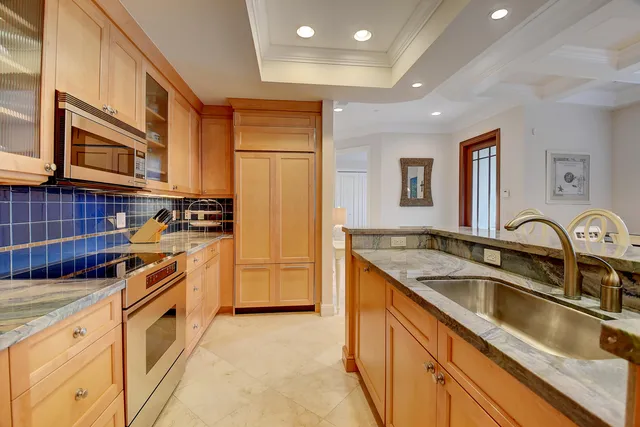 a kitchen with stainless steel appliances granite countertop a sink stove and cabinets