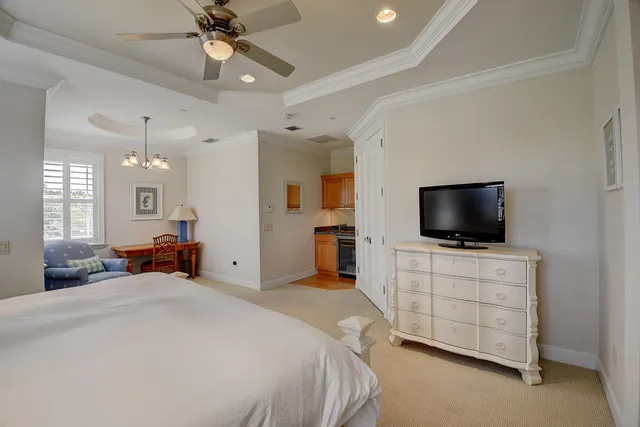 a bedroom with a bed and a flat tv screen on dresser