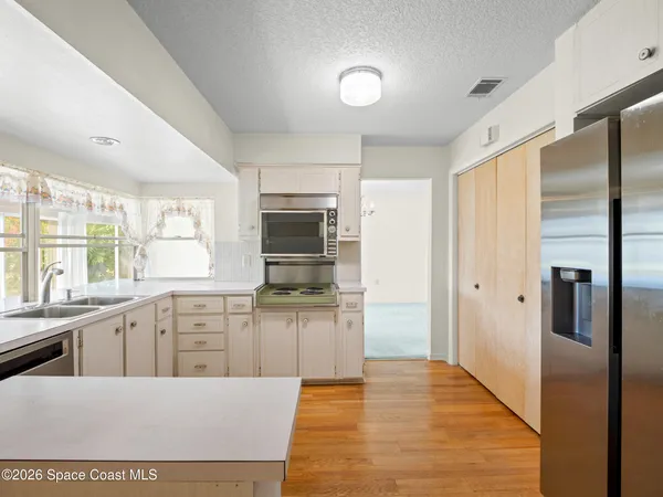 a kitchen with stainless steel appliances granite countertop a refrigerator and a stove top oven