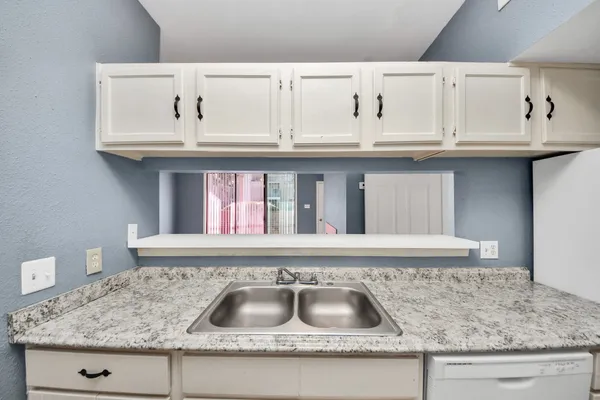 a kitchen with granite countertop a sink and cabinets