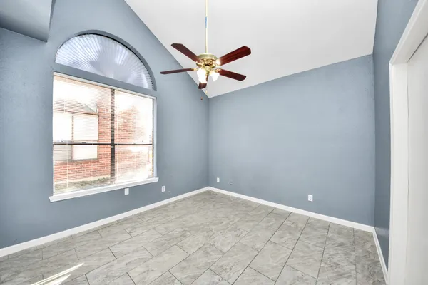 an empty room with windows and fan