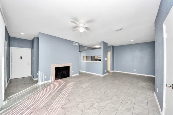 a view of an empty room with a fireplace and a window