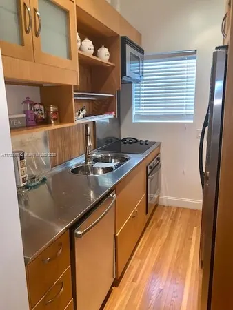 a kitchen with stainless steel appliances granite countertop a sink stove and cabinets
