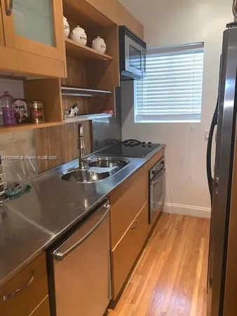 a kitchen with a sink appliances and cabinets