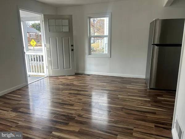 an empty room with wooden floor and a window
