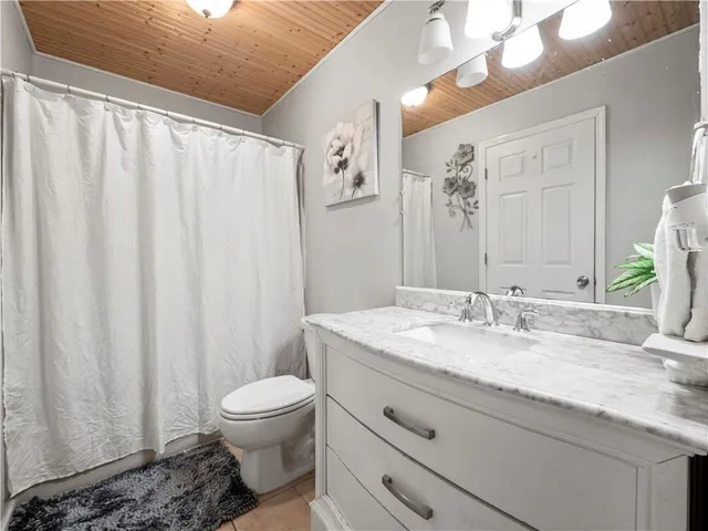 a bathroom with a granite countertop sink toilet and mirror