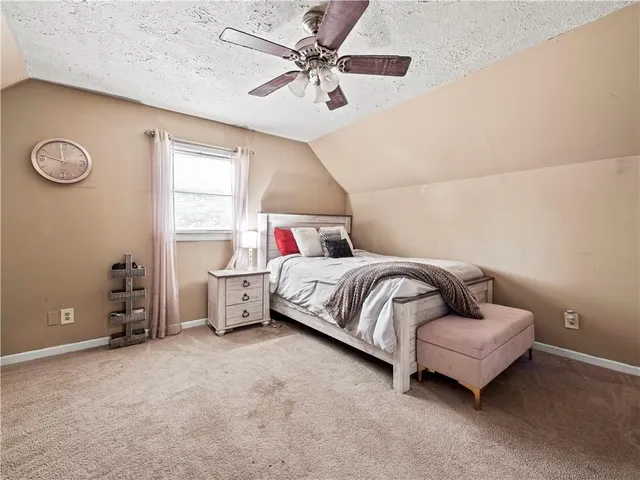 a bedroom with a bed and a ceiling fan