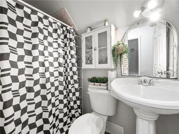 a bathroom with a sink and mirror with toilet