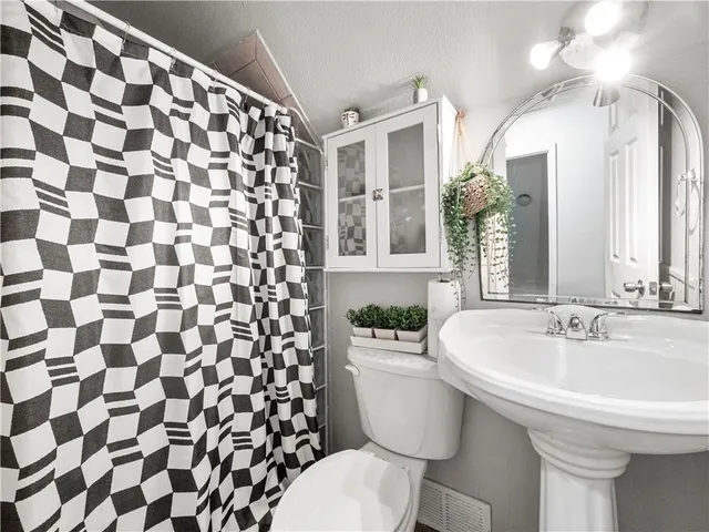 a bathroom with a sink and mirror with toilet