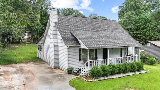 a view of a house with brick walls and a yard with plants