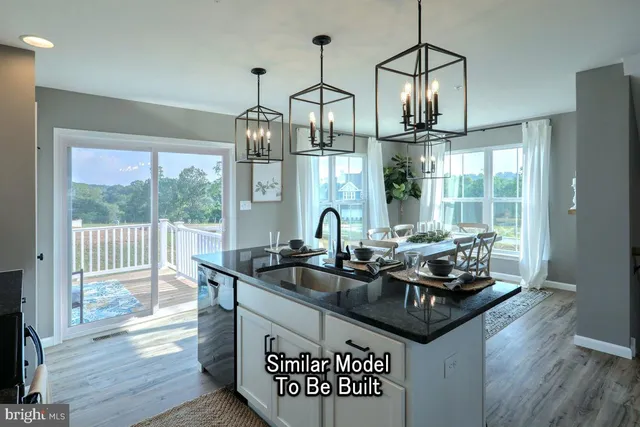 a kitchen with stainless steel appliances granite countertop a sink a stove and a wooden floor