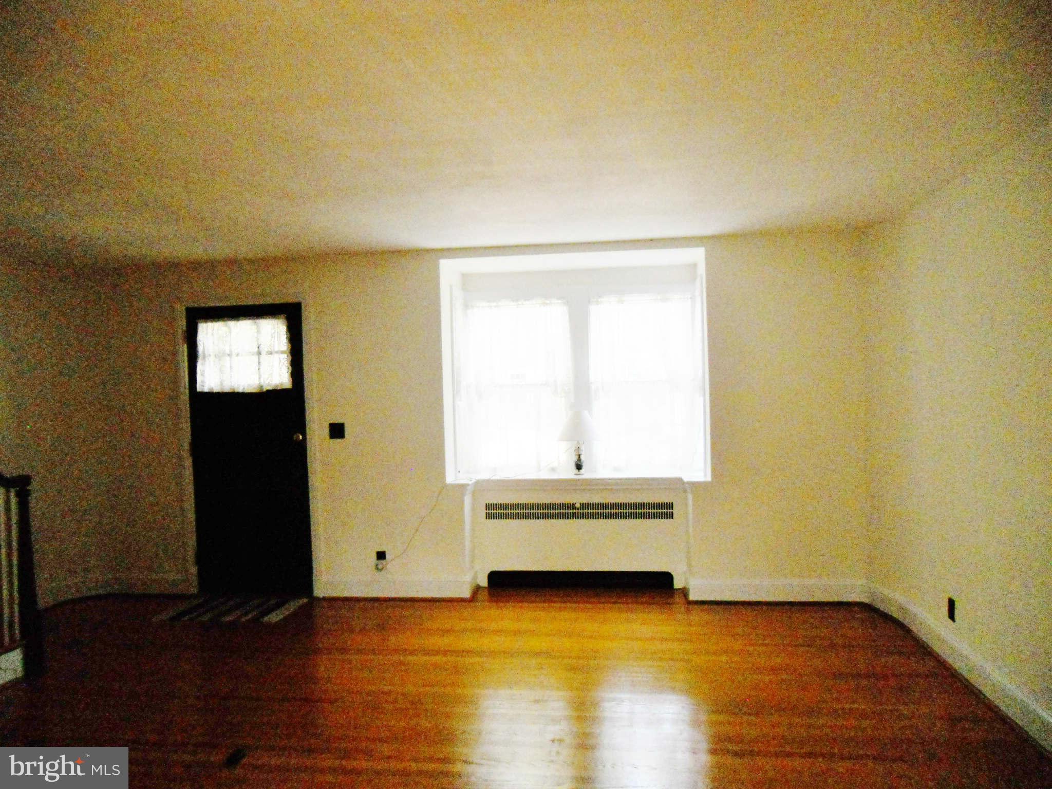 313 Murdock Road Baltimore, MD 21212 - Photo 3 of 15 a view of an empty room with wooden floor and a window