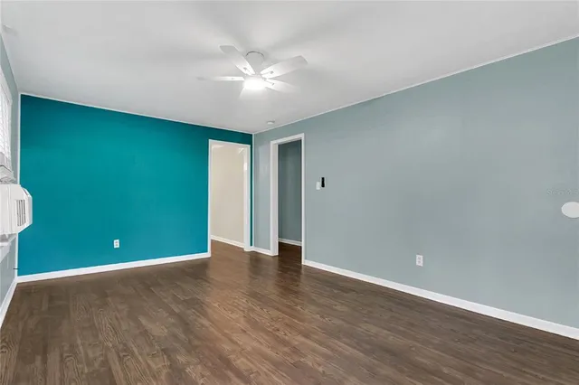 a view of an empty room with wooden floor