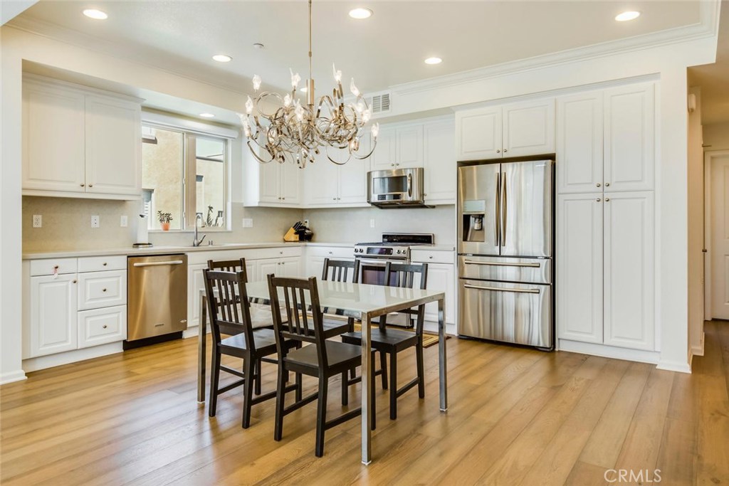5439 Strand, Unit 101 Hawthorne, CA 90250 - Photo 6 of 23 a kitchen with stainless steel appliances a dining table chairs stove and refrigerator