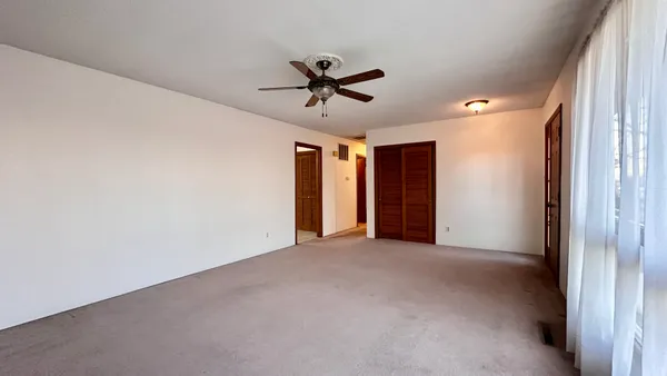 a view of a livingroom with a ceiling fan and window
