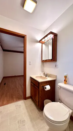a bathroom with a granite countertop toilet sink and mirror