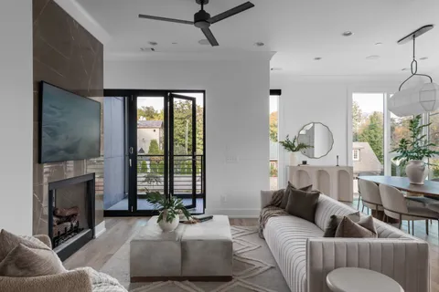 a living room with furniture a fireplace and a floor to ceiling window