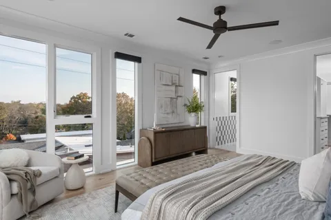 a bedroom with a bed couch and large window