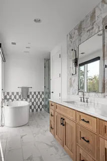 a spacious bathroom with a double vanity sink mirror and bathtub