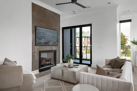 a living room with furniture a fireplace and a large window