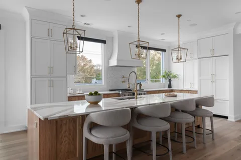 a kitchen with granite countertop a sink a center island and chairs
