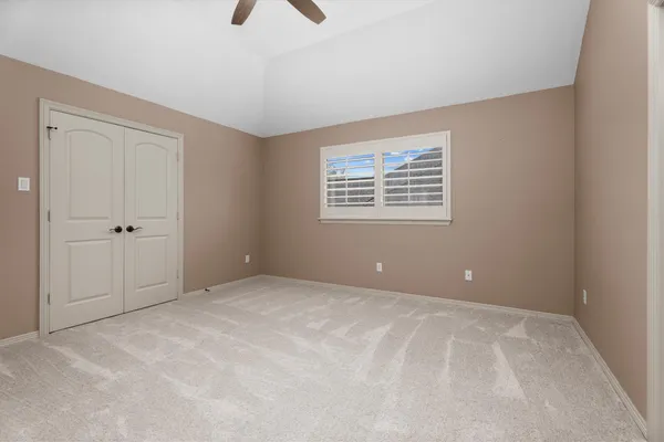 a view of an empty room with window and cabinet